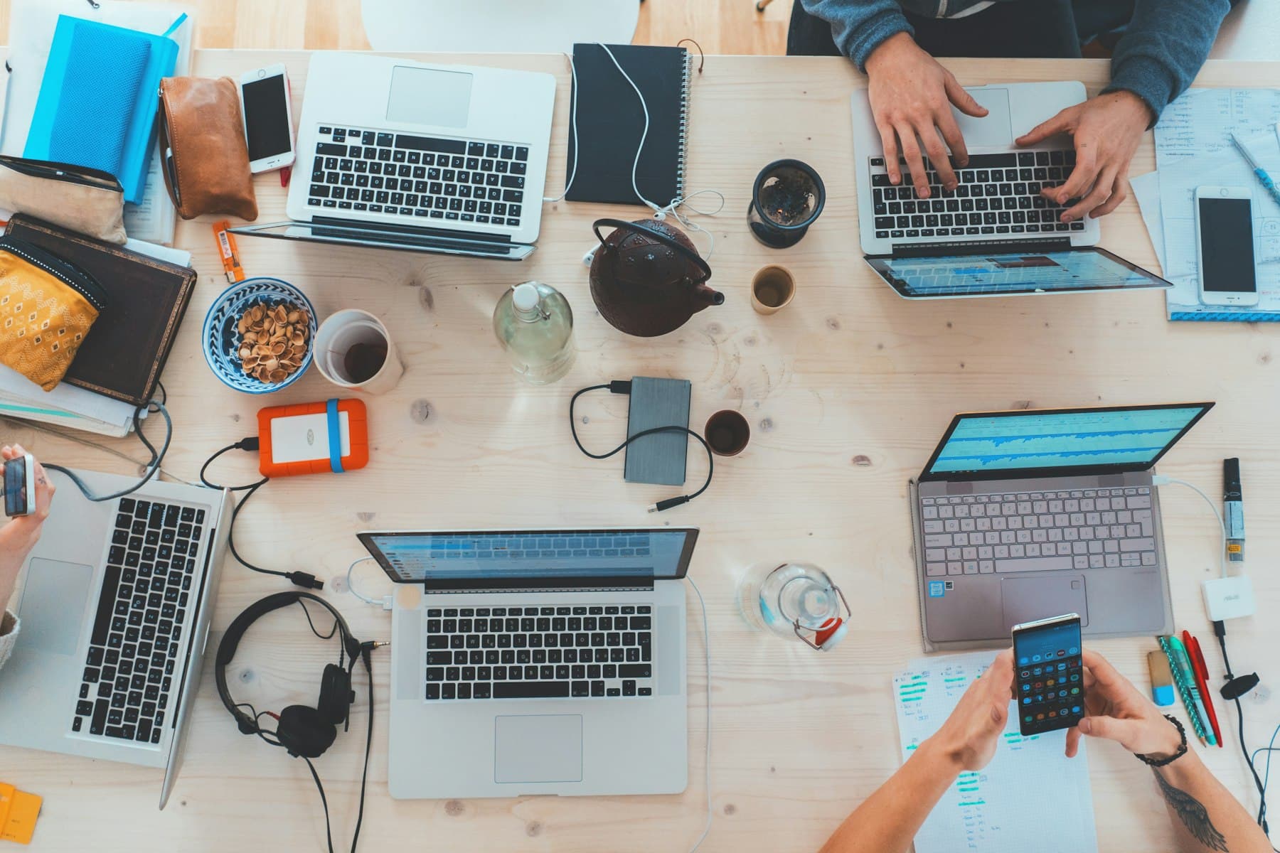 People working on laptops together at a shared table